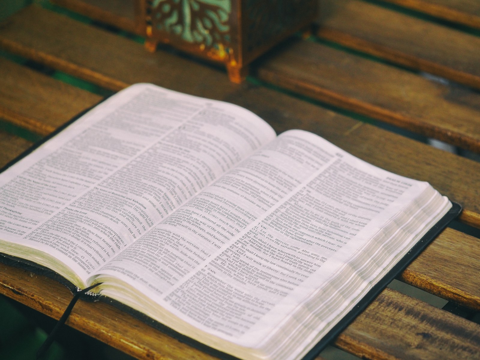 Una Biblia abierta sobre una mesa de madera, iluminada con luz suave.